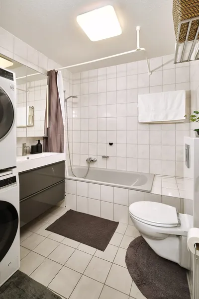 Bathroom with bathtub and washer-dryer in Landstuhl TLA apartment near Ramstein