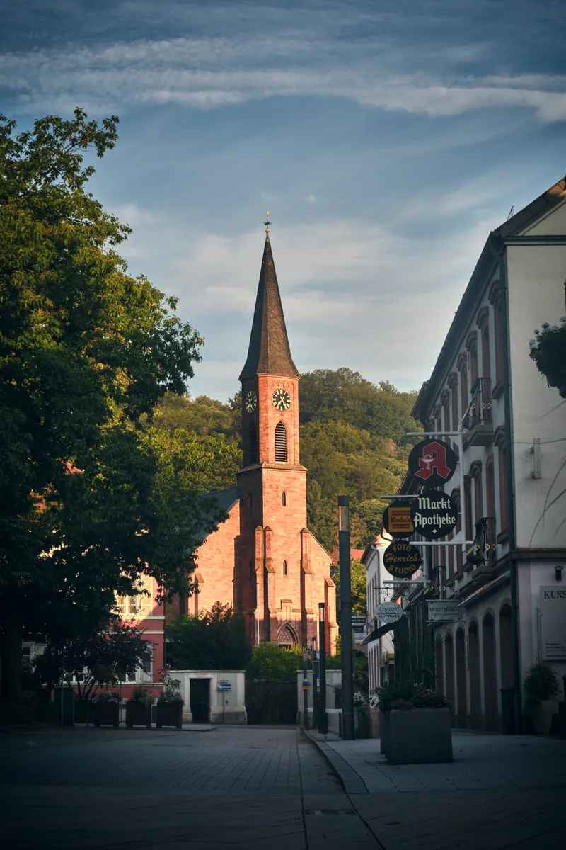 Tree-lined street in Landstuhl leading to a church spire
